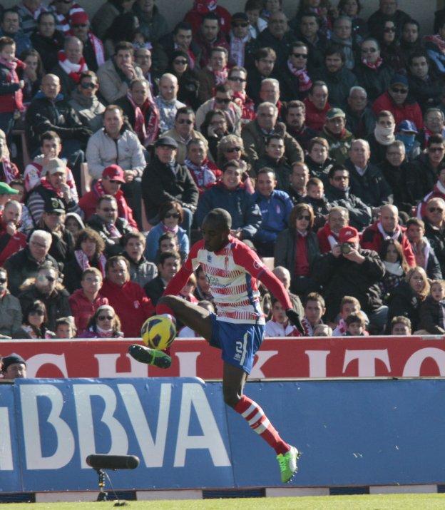 Allan Nyom controla el balón pegado a la línea de cal, con la afición atenta.