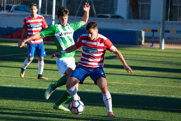 Un jugador del primer equipo juvenil del Granada protege el balón en un partido. /ESTA ES TU GRADA