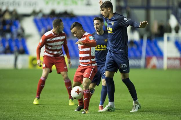 Juancho mantiene el balón en su poder acosado por dos contrarios./PASCU MÉNDEZ / LOF