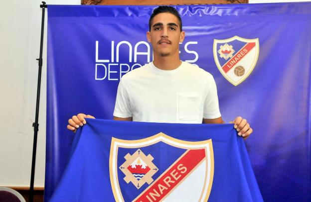 David Pinto Robador posando con la bandera del equipo linarense./ENRIQUE
