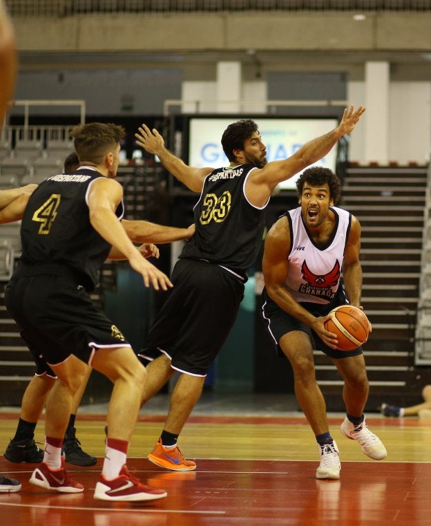 Devin Wright (d) avanza con fuerza hacia el aro a través de la defensa de Benahavís.