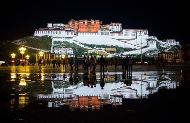 Los turistas se arremolinan frente al Palacio Potala, cuya estampa se refleja de noche en el agua creando la ilusión de un mar lácteo. ::/JOHANNES EISELE / AFP