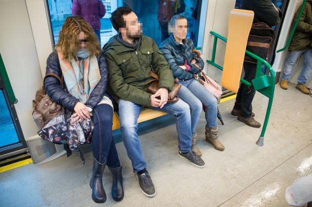 Un hombre con las piernas abiertas invade el espacio de dos usuarias del metro de Granada./JORGE PASTOR