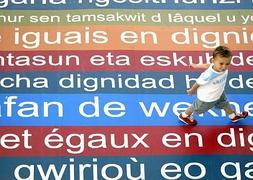 Un niño camina sobre una alfombra con mensajes en diferentes idiomas. :: REUTERS/