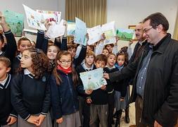 Representantes de la asociación recogen los dibujos realizados por los niños del colegio Carmen Sallés de Santa Fe. :: ALFREDO AGUILAR/