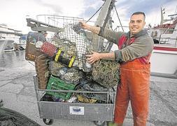 Un marinero con los residuos que han quedado atrapados en las redes de su barco. A partir de ahí se separan y reciclan :: JAVIER MARTÍN/