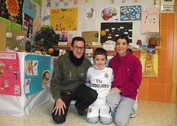 Javier posas con sus padres, Javier y Belinda, en las instalaciones del colegio. :: I. SÁNCHEZ/