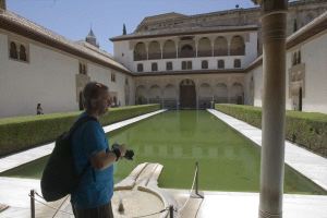 Un visitante observa uno de los patios de la Alhambra. / G. MOLERO/