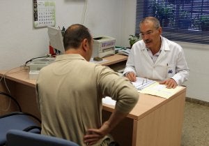 Un trabajador le indica al médico donde tiene su dolor de espaldas. /IDEAL/