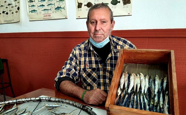 Manuel González muestra la 'arnuera' en la que se seca el pescado y una caja de pescado seco. /M. TORRES