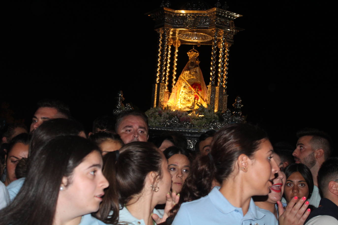 Jóvenes anderas acompañan a la Virgen en su procesión nocturna. 