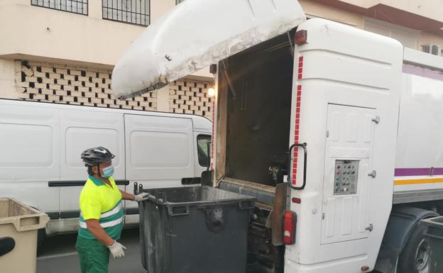 Los operarios de recogida de basura proceden a desinfectar los contenedores.